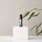 Roll-on Whisper Touch dōTERRA 10ml — frasco en cubo blanco con espejo circular y eucalipto