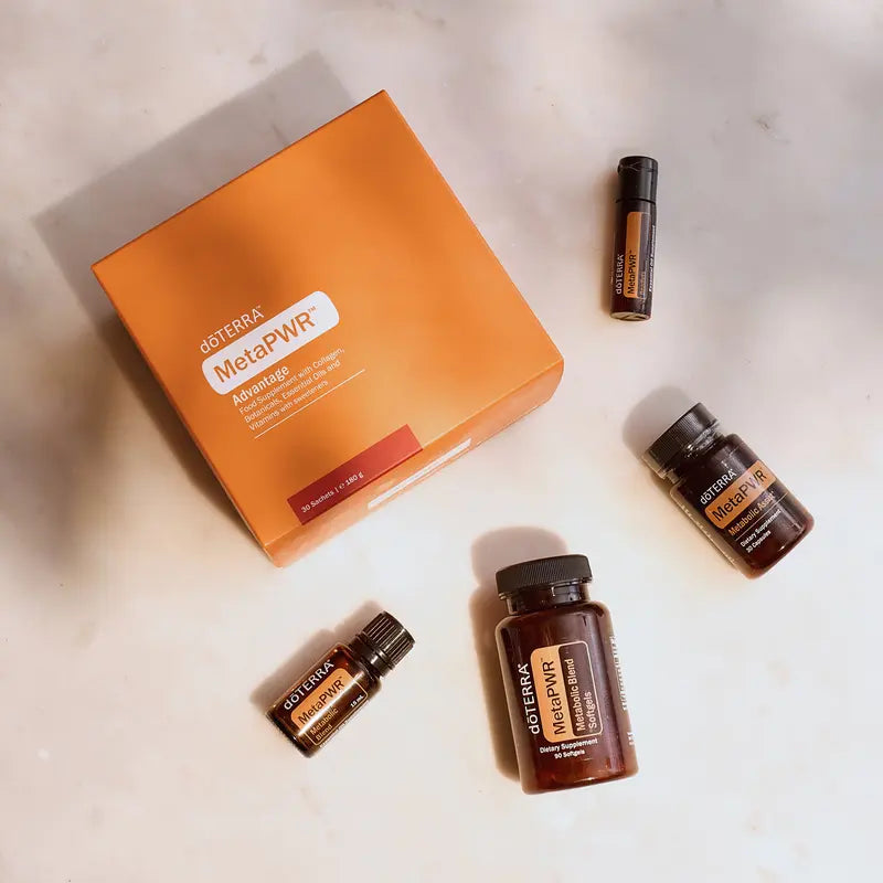 Sistema MetaPWR™ dōTERRA 2026 — colección completa sobre mármol en vista cenital, toma 1
