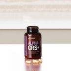 Frasco abierto de Alpha CRS+ dōTERRA con cápsulas amarillas sobre encimera de madera
