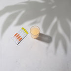 MetaPWR™ Advantage dōTERRA — sobres y vaso naranja sobre mármol con palmera al fondo