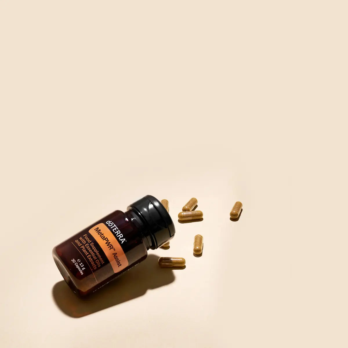 Meta-PWR™ Assist dōTERRA EU — frasco tumbado con cápsulas sobre fondo beige