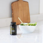 MicroPlex VMz dōTERRA — cápsulas junto a ensalada sobre mármol