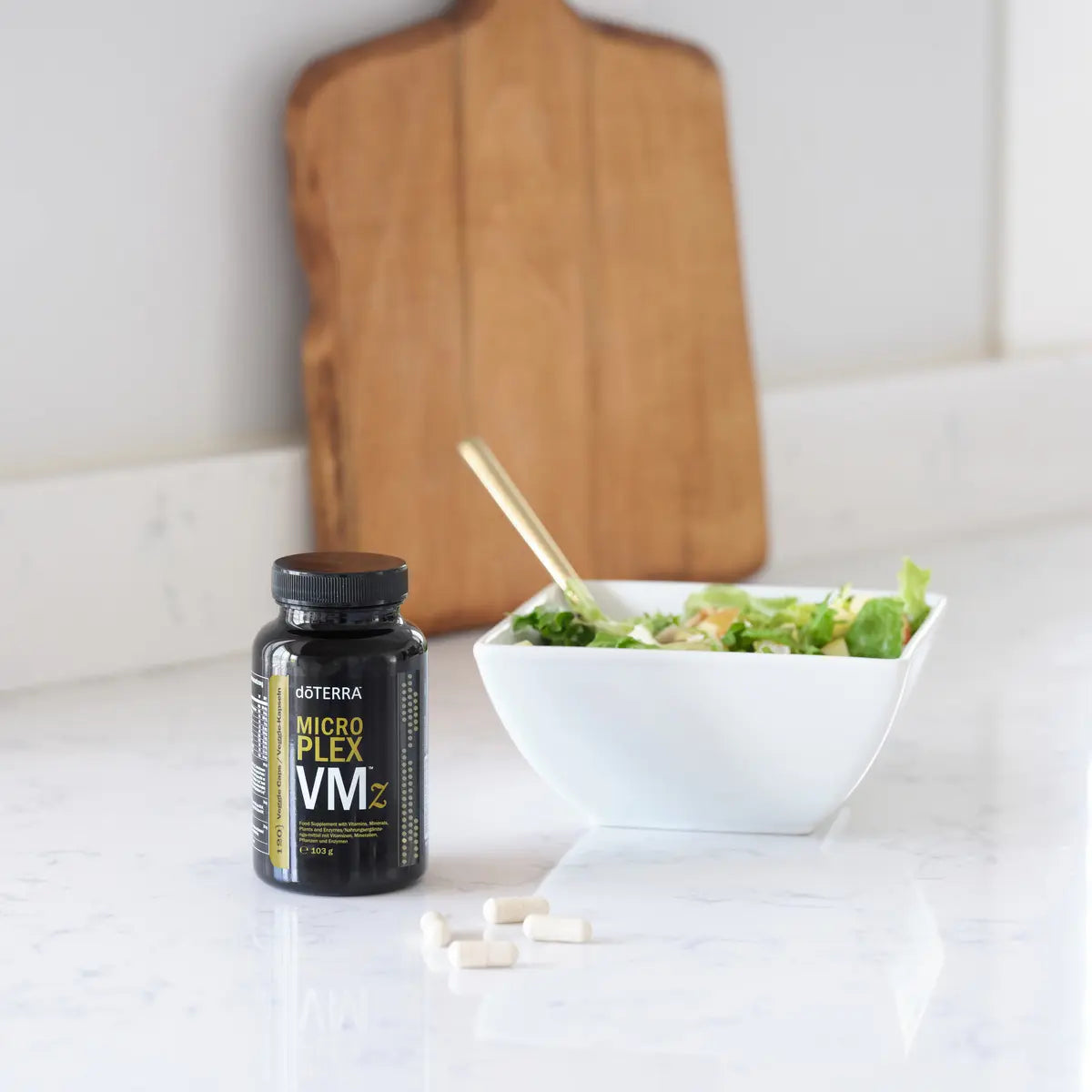 MicroPlex VMz dōTERRA — cápsulas junto a ensalada sobre mármol