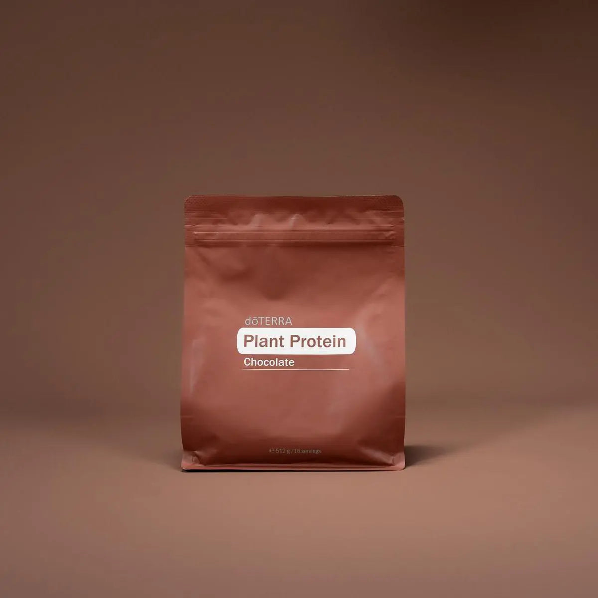 Bolsa de proteína vegetal de chocolate dōTERRA sobre fondo marrón en estudio