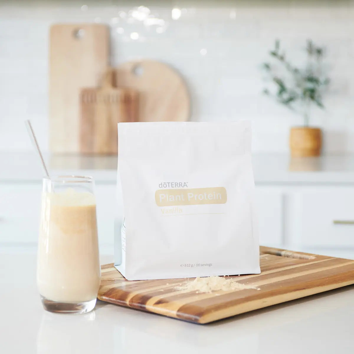 Bolsa de proteína vegetal de vainilla dōTERRA 512g junto a un batido verde sobre tabla de madera