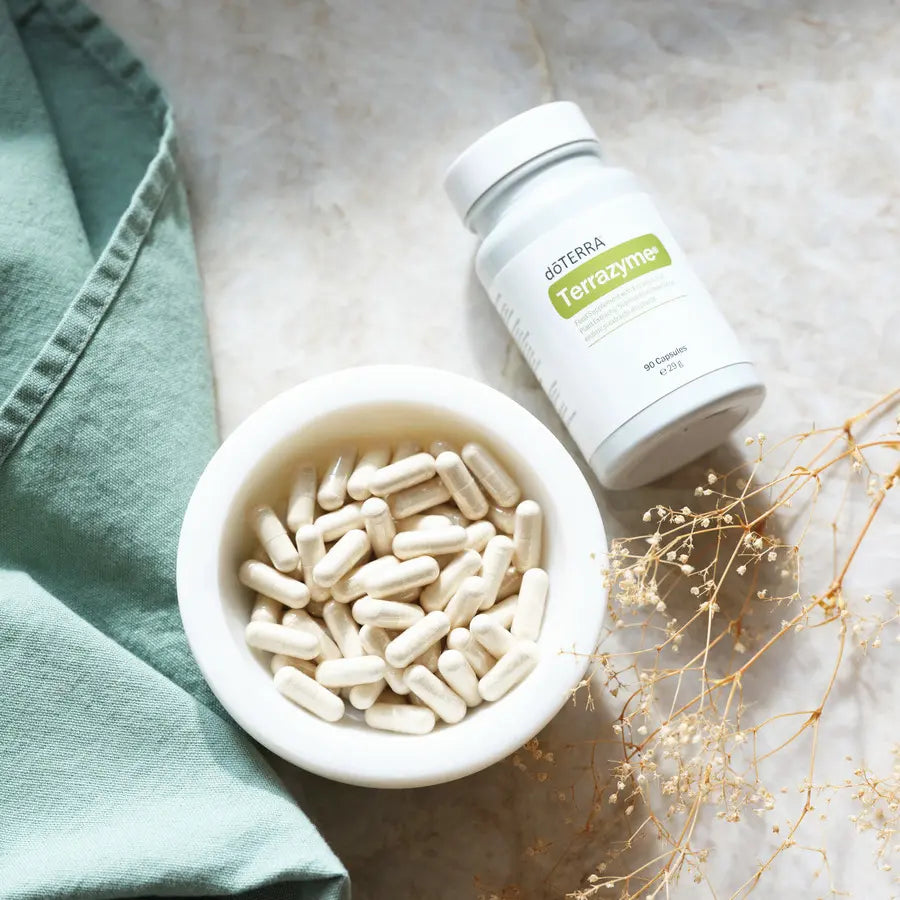 TerraZyme dōTERRA 90 cápsulas en cuenco blanco con flor seca visto desde arriba