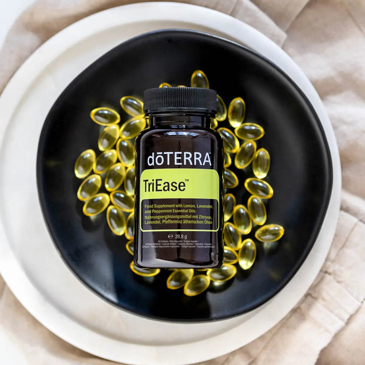 Softgels amarillos de TriEase dōTERRA 60ct en cuenco negro visto desde arriba