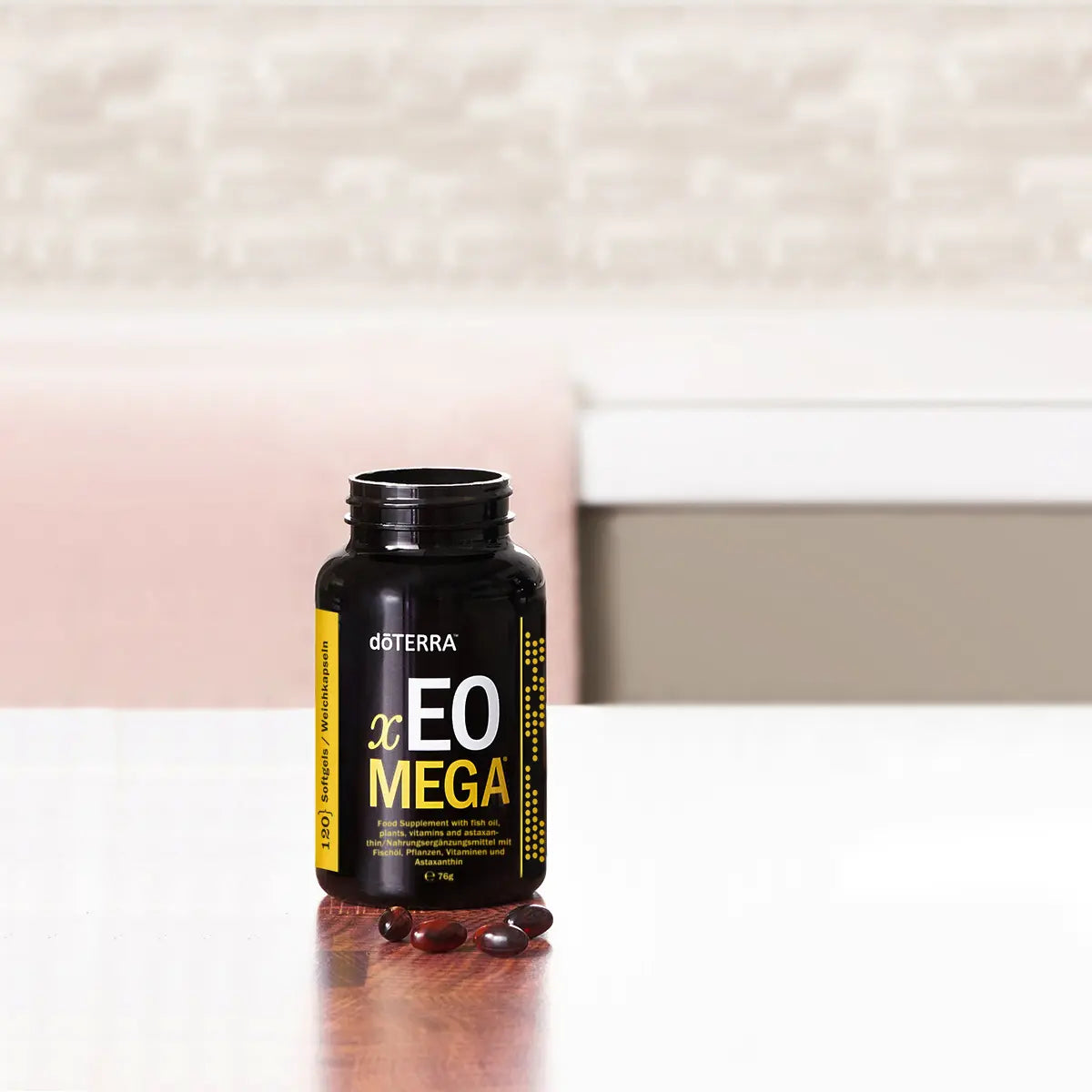 Frasco abierto de Xeo Mega dōTERRA 120ct con softgels rojos sobre encimera