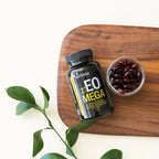 Frasco de Xeo Mega dōTERRA 120ct con softgels rojos en cuenco sobre tabla de madera