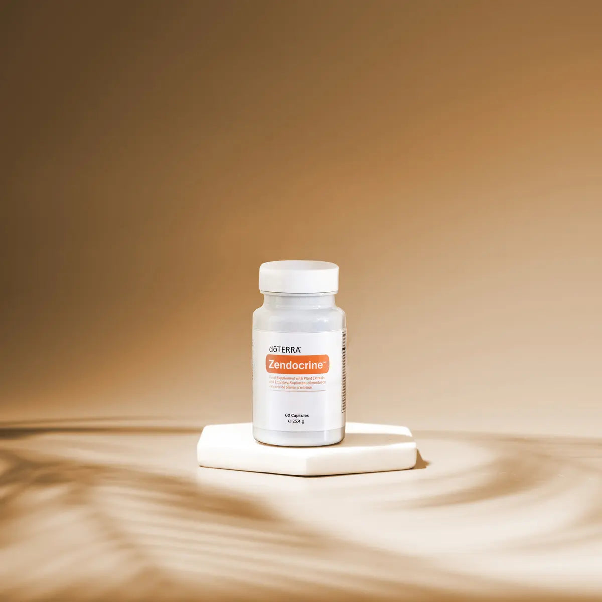Frasco blanco de Complejo Zendocrine dōTERRA 60ct sobre pedestal con fondo beige