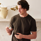 Hombre moreno sosteniendo frasco de Complejo Zendocrine dōTERRA 60ct